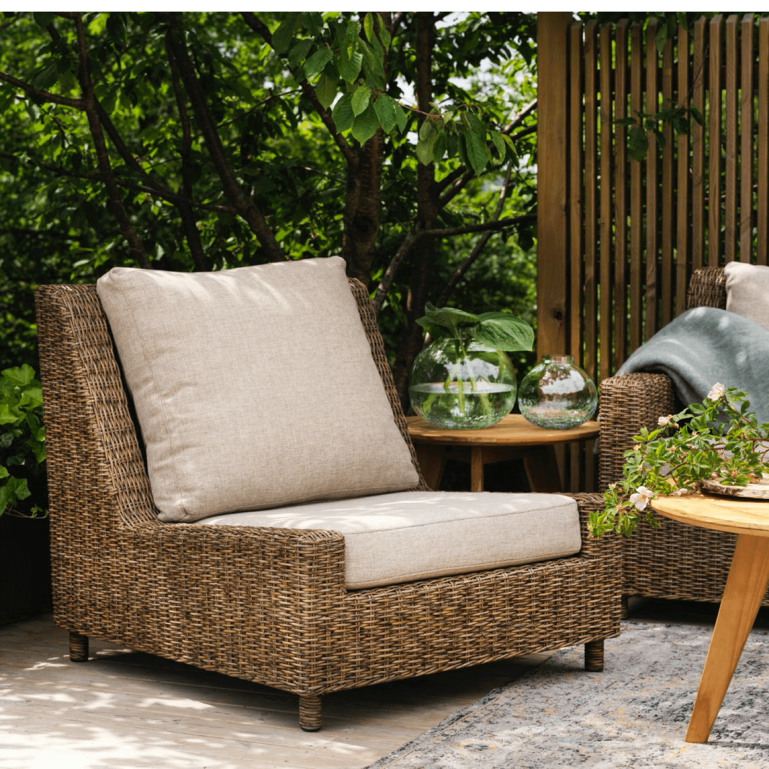 loungestol i konstrotting med dyna i färgen natur/sand i utomhusmiljö