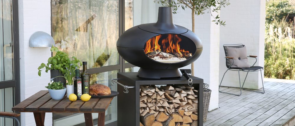 En lite mindre svart grill och ett bord med tillbehör till grillningen